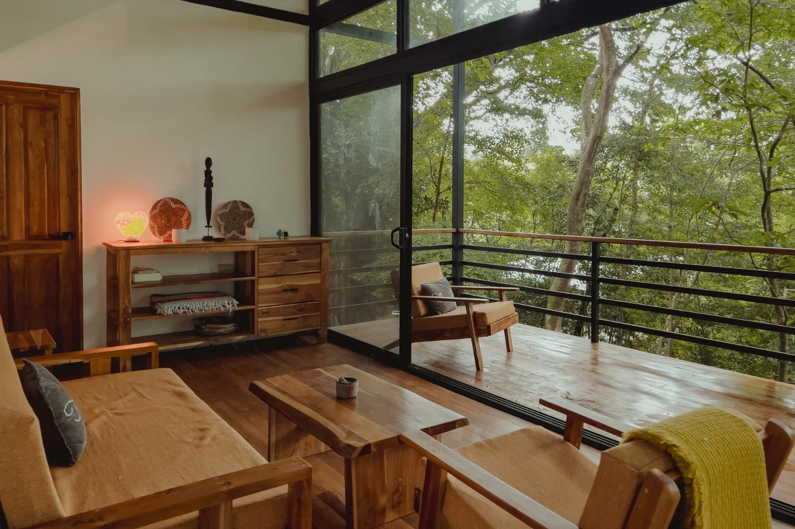 Private accommodation opening onto a balcony surrounded by forest